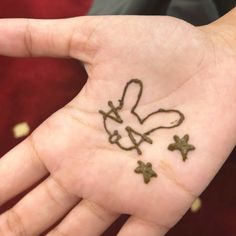 a person's hand with a tattoo on it that has crosses and hearts drawn on it