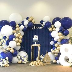 a blue and white balloon arch with balloons