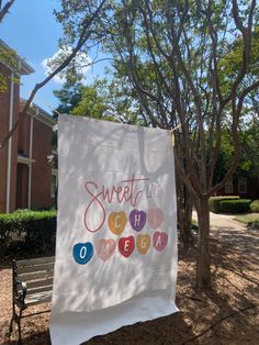 a banner hanging on a tree in front of a building