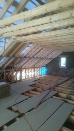 an unfinished attic with wooden beams and exposed floor joisting in the foreground