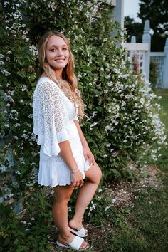 Minneapolis based senior photographer captures photos of a dreamy senior session outside for a girl wearing spring styled outfits including a white dress with sleeves, a short blue dress, and a black tshirt with white and black striped pants. #seniorgirloutfitideas #minnesotaseniorphotographer #minneapolisseniorphotographer #seniorphotoshootinspiration #seniorgirlposes #springseniorphotoshoot