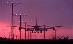 an airplane is taking off from the runway at sunset or dawn with its landing gear down