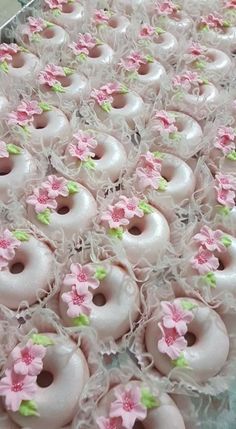 there are many donuts with pink flowers on them