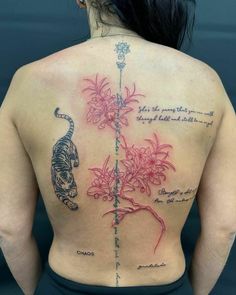 the back of a woman's upper body with tattoos on her chest and flowers