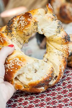 a person holding a piece of bread with poppy seed sprinkles on it