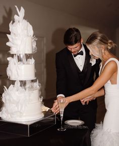 a bride and groom cutting their wedding cake