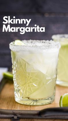 two glasses filled with lemonade sitting on top of a cutting board next to limes