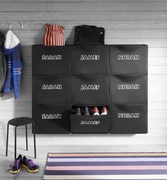 an organized closet with shoes and bags hanging on the wall next to a striped rug