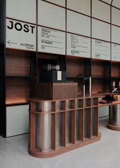 the interior of a coffee shop with wooden shelves and metal stools on each side