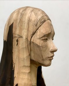 a wood carving of a woman's head with long hair