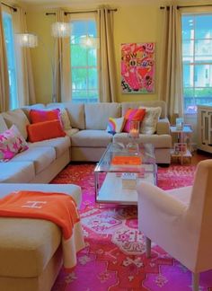 a living room filled with lots of furniture and colorful rugs on the floor in front of large windows