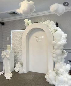 a white arch decorated with balloons and flowers