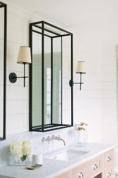 a bathroom with two sinks and mirrors on the wall