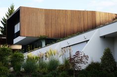 a modern house with an unusual roof and wooden slats on the top of it