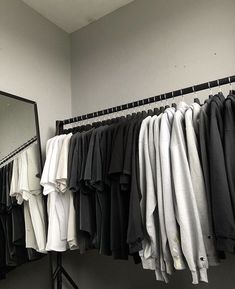 clothes are hanging on a rack in front of a mirror