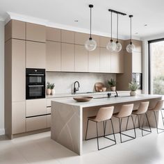 a modern kitchen with an island counter and bar stools