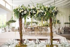 the tables are set with white flowers and greenery