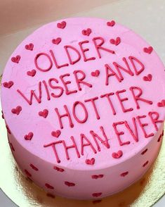 a pink cake with red hearts on it that says older wiser and hotter than ever