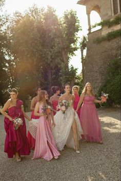 a group of women in long dresses standing next to each other on a gravel road