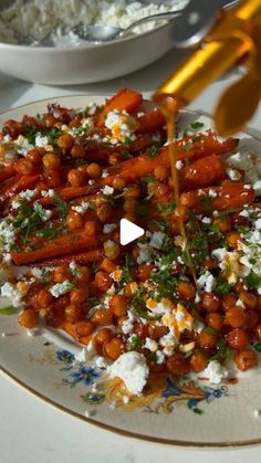 a plate with carrots and feta cheese is being drizzled over