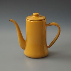 a yellow teapot sitting on top of a table