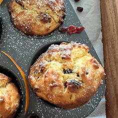 four muffins sitting in a pan with fruit on the side