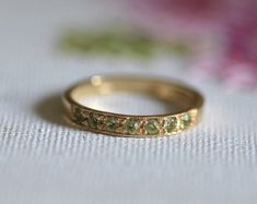 a close up of a gold ring with flowers in the background