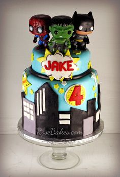 a birthday cake with three little superheros on top