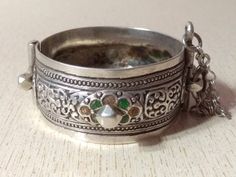 A superb old Berber silver bracelet from Morocco. The surface of the bangle has been finely hand-etched with a design combining lines with enamel, and the surface as well as interior have both obtained a very rich patina from wear and usage. It opens and closes with a pin. Inner diameter : 5,6 cm (2,2 inches) Width : 2,8 cm (1,1 inches) Weight : 73,6 g Vintage Engraved Bangle For Festivals, Antique Silver Openable Jewelry, Traditional Engraved Sterling Silver Bracelet For Formal Occasions, Silver Openable Bracelets As A Gift, Silver Openable Bracelets For Gift, Silver Openable Bracelet For Gift, Silver Openable Jewelry For Formal Occasions, Ceremonial Silver Openable Bangle, Ornate Stamped Bracelet Jewelry