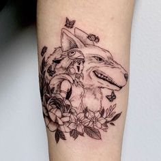 a tattoo on the leg of a woman with a wolf and flowers