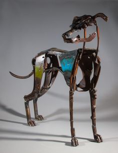 a dog made out of metal and wood with blue paint on it's body