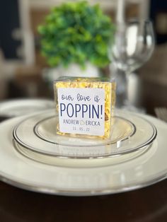 a plate with a small box of popcorn sitting on it's center piece, which reads born love is poppin