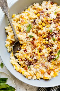 a bowl filled with corn and topped with parmesan cheese