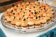 a platter filled with mini hamburgers and playing cards on top of each other