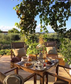 a table with food and drinks on it in the middle of an outdoor patio area