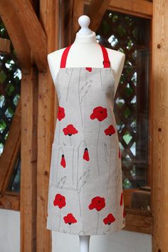 an apron on a mannequin with red flowers