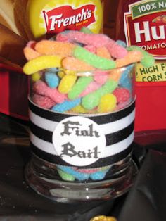 a glass filled with gummy bears sitting on top of a counter next to a bag of chips