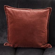 a brown velvet pillow sitting on top of a black couch