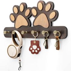 wooden key holder with paw prints on the front and two keys hanging from it's hooks