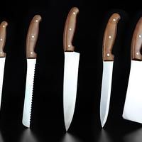 five knives with brown handles are lined up against a black background and one has a knife in the middle