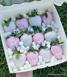 chocolate covered strawberries in a white box on the grass with pink and white decorations