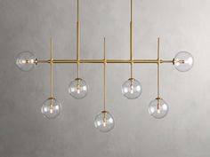 a brass chandelier with five clear glass globes hanging from the ceiling,