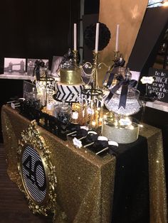 the table is set up with black and gold decorations