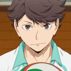 an anime character with brown hair and blue eyes holding a green object in his hand