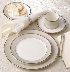 a table set with white plates, silverware and napkins on top of it