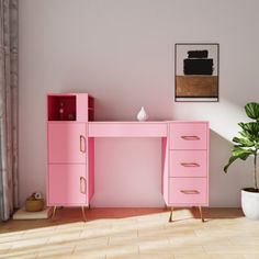 a pink desk with two drawers and a potted plant in the corner next to it