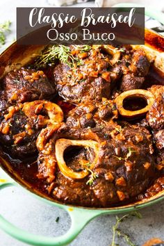 a close up of food in a pan with the words classic braised osso buco