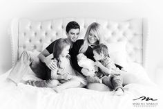 a family sitting on top of a bed together