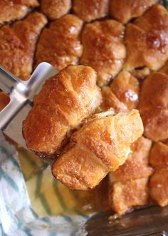 croissants being cut into pieces on a glass plate with utensils