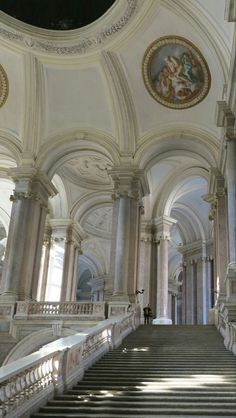 an ornate building with stairs and paintings on the walls